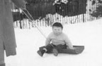 Roger on a sled in the snow in the early 1960s