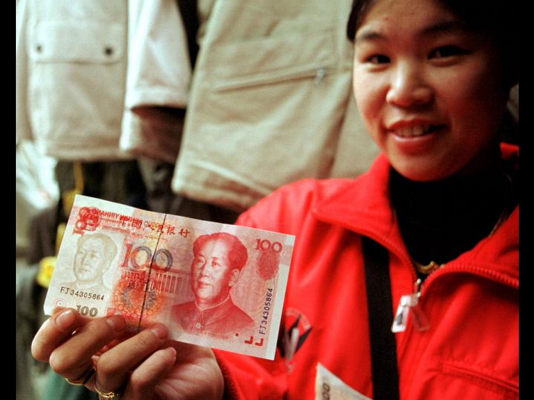 Photo of a woman holding up a 100 Yuan note