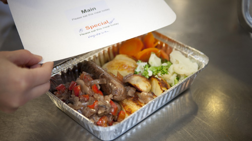 a foil serving tray containing a freshly cooked meal