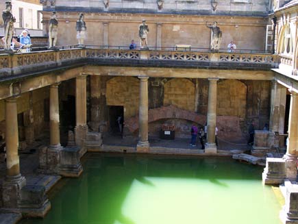 Roman columns and statues surround a pool of greenish water: the famous mineral spring of Bath in southwest England