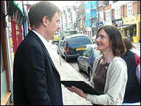 Man being interviewed by woman with clipboard