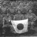 This picture was taken in 1945 while marching into Kagoon.Georges father is on the bottom row on the far right.
