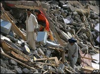 Paquistaneses procuram pertences em escombros em Muzaffarabad