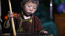 Shoree ym Mongolia yn helpu ei mam gyda choginio © Timothy Allen