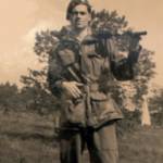 Peter John Page with Bren gun on the German frontier, 1944/5. Note German surrender flag hanging from the tree on Peter's left hand side.