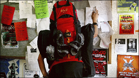 A backpacker checks a noticeboard in Australia