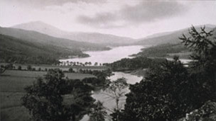 Black and white view of Loch Tummel and surrounding hills with pointed peak of Schiehallion beyond