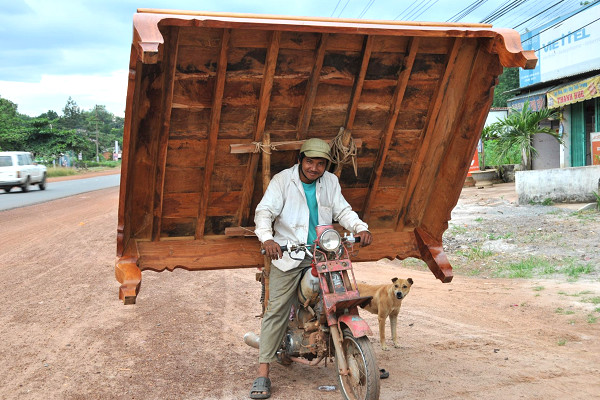 Một người đàn ông chở phản bằng xe máy