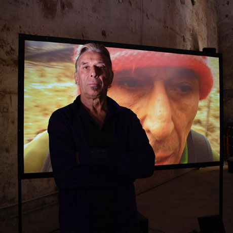John Cale standing in front of his video installation, 2009. Photography by Prudence Cuming © The British Council