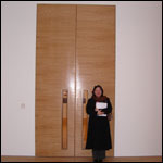 Carol stood next to the tall doors