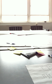 Meeting room with paper, pens and post-its on the table
