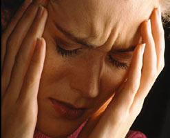 A frowning woman with hands to her head