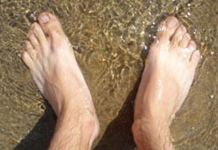 A man's feet under water on a beach (credit: Benjamin Dudoit)