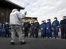 Man in white standing in front of group of children wearing masks