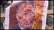 Pôster com foto do presidente Kurmanbek Bakiyev coberto de sangue