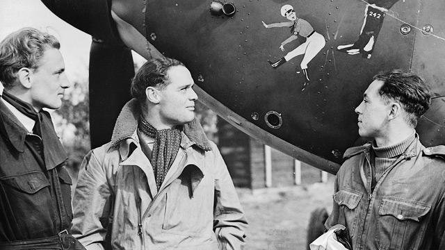 Squadron Leader Douglas Bader, the renowned fighter ace, and fellow pilots study a caricature of Hitler painted on a Hawker Hurricane in October 1940.