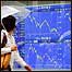 Pedestre observa indicadores econômicos no Japão