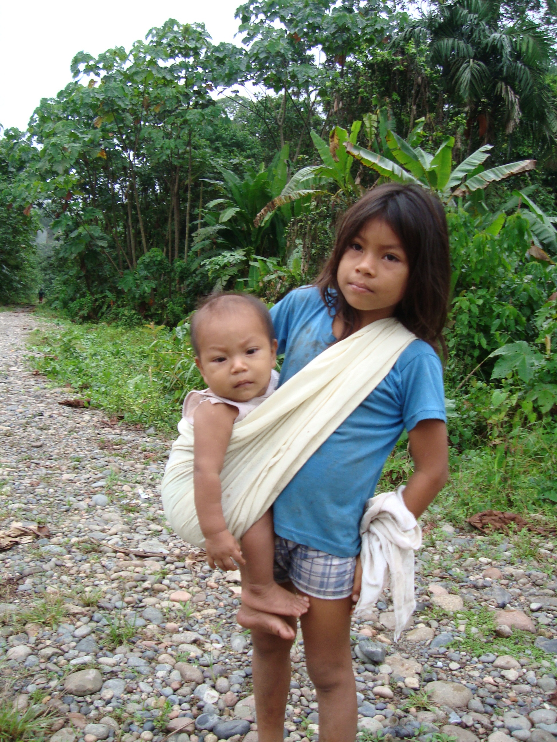 A young girl with holding a baby.