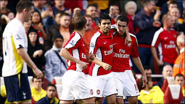 Arsenal celebrate their opening goal as Robbie Keane (left) looks on