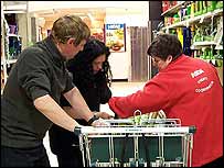 Gail leaning into the trolley to add up the value of the goods