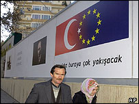 İlan panosunun önünde iki kişi