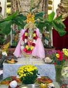 Statue of the elephant-headed Ganesh, surrounded by flowers, plants and offerings
