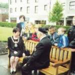 Mr Jim Jolly, Secretary of Branch No 51 (West Cumbria) of the Normandy Veterans Association talks to the Mayor of Copeland Mrs Joan Hully and primary school children from Whitehaven about the Normandy Memorial Seat. (St Nicholas Church Gardens, Whitehaven, Cumbria, 6 June 2000)