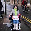 Arunima going down a Cambridge street in her chair in the rain