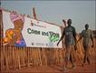 Two men walk past a poster encouraging people to vote in Rumbek, Sudan.