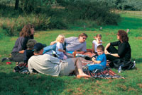 Teulu'n cael picnic © Bwrdd croeso Cymru