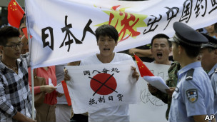 北京反日示威者在日本大使館外舉起呼籲中國民眾抵制日貨的標語（13/9/2012）