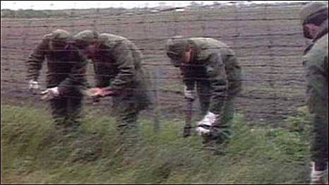 Hungarian soldiers cutting the barbed wire on the Hungarian border