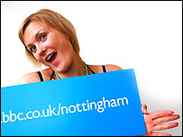 Laura holds up a bbc.co.uk/nottingham sign