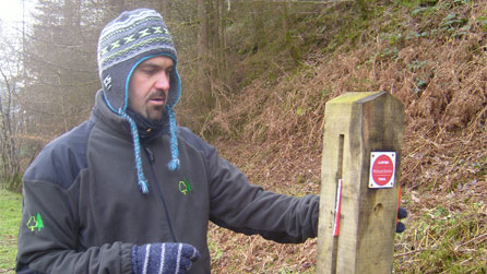 Jonathan Price, Ranger with the Forestry Commission with a vandalised sign.