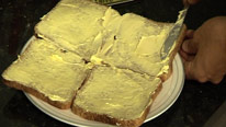 Spreading maragarine on 4 slices of bread