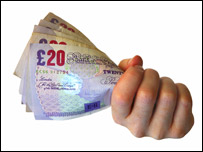 A hand holding £20 notes