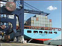 Ship next to crane with line on lorries alongside