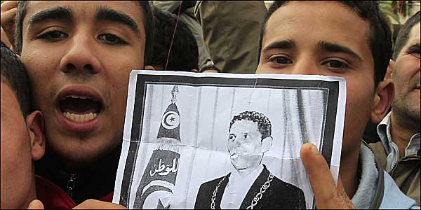 Young men hold a picture of Mohamed Bouazizi