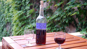 A bottle of red wine with two glasses
