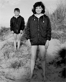 A young brother and sister on the beach in aroraks