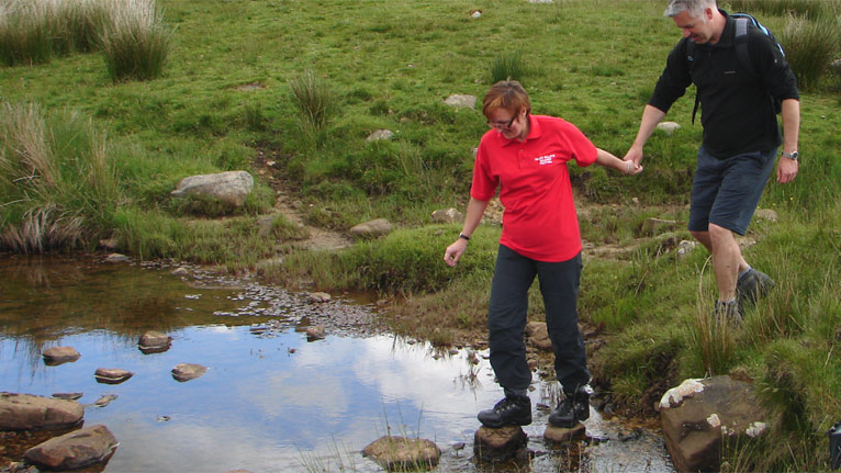 Derek and guide cross the stream