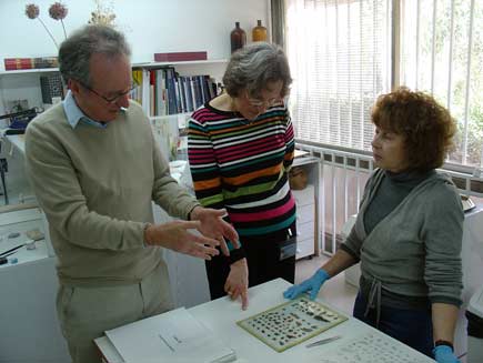 Roger Bolton, Pnina Shor and restorer Elena looking at some scroll fragments