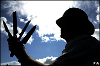 PC Alan Bell holds knives and an axe handed in to North Shields police station / Owen Humphreys/PA