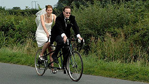 Bethan and her husband with their tandem on their wedding day.