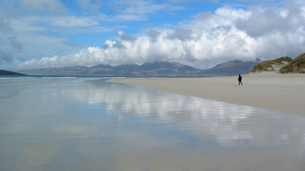 A lovely long, white beach with blue skies above