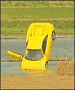 An upturned Lambourghini in a field. 