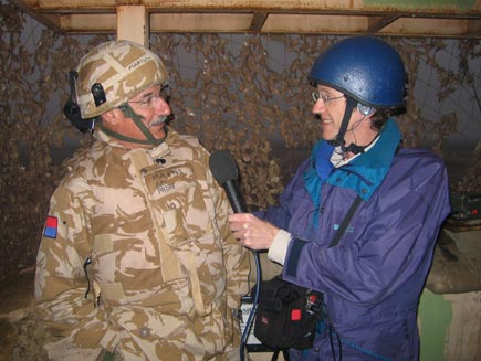 Phil Pegum and Chaplain Andrew Martlew standing in a camouflaged watch tower 