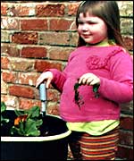 Sophie stands by her planter.