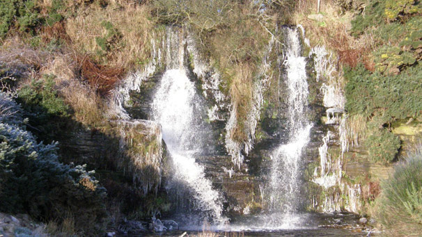Waterfall surrounded by frozen spray