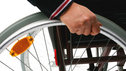 Hand on wheel of wheelchair
